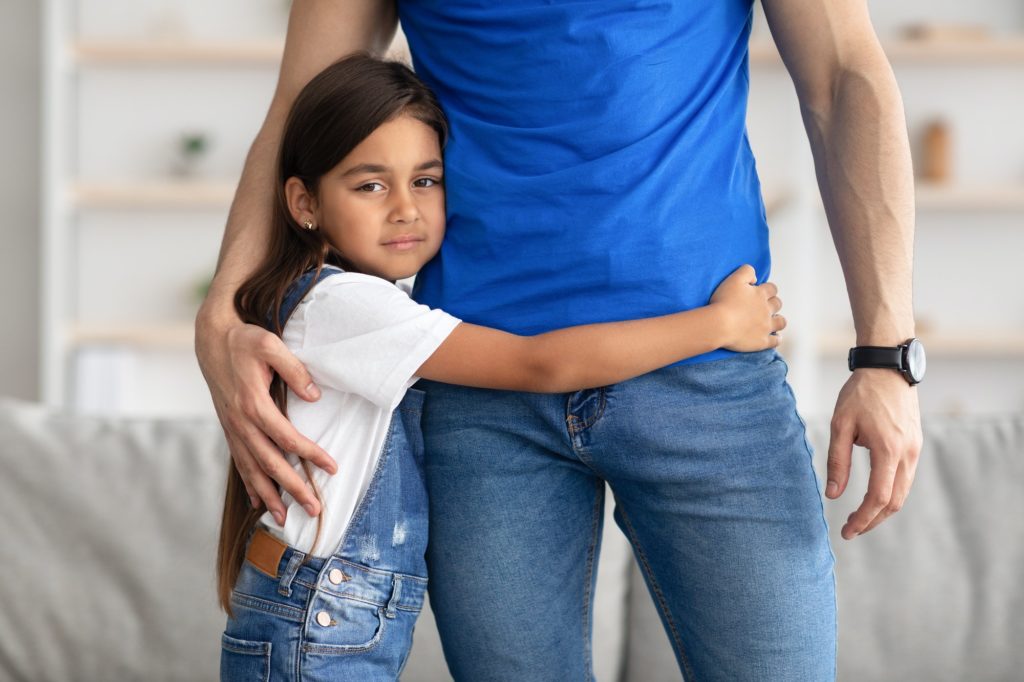 Portrait of father and daughter hugging at home